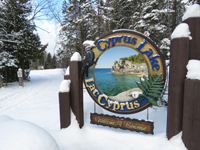 A sign for Cyprus Lake covered in snow